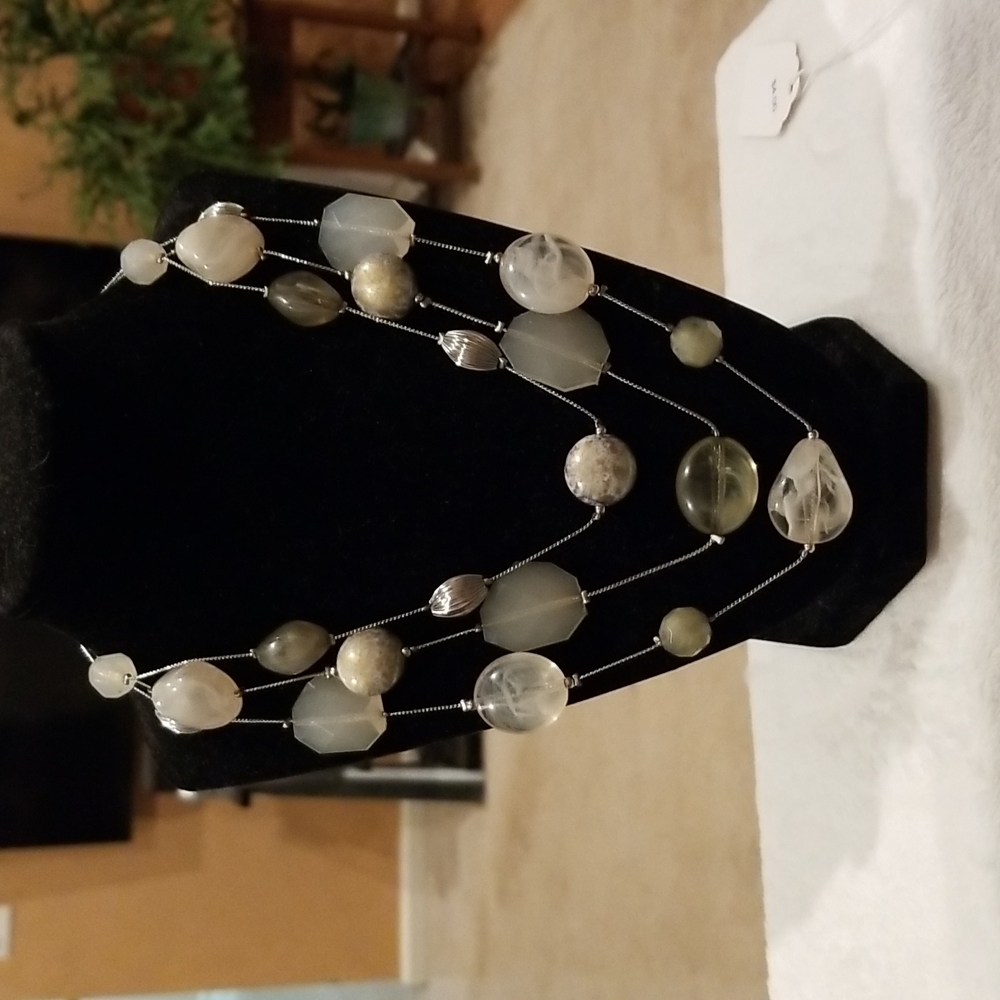 Polished beaded necklace jade in color with silver beads.